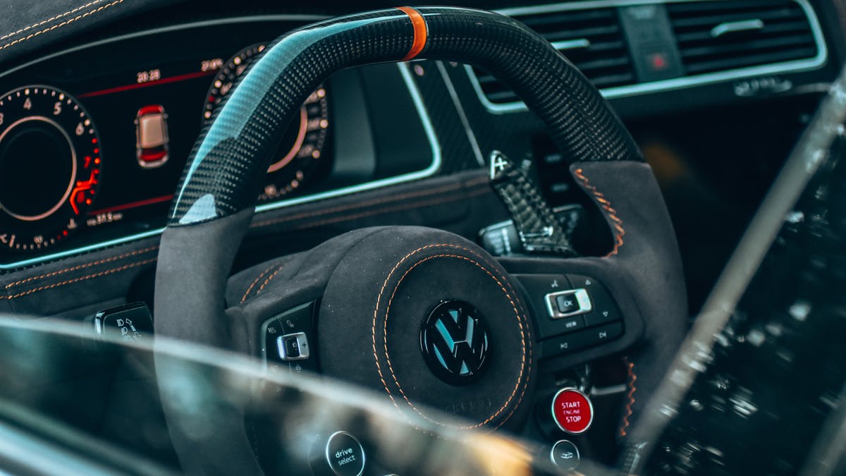 Close-up of a car steering wheel and dashboard — premium hi-tech brake pedal lock features