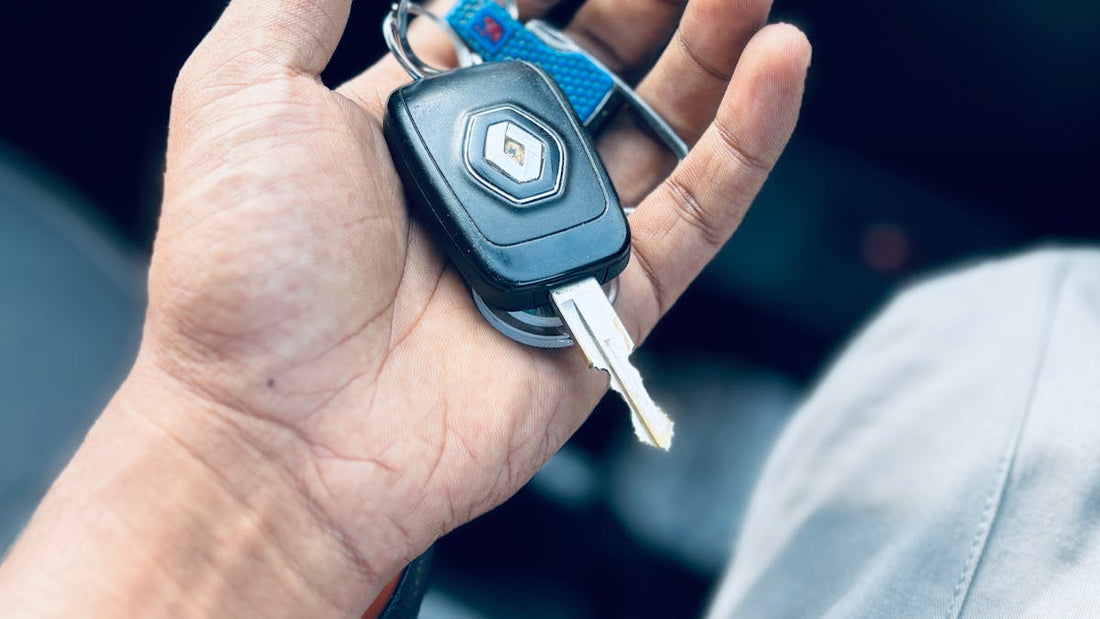 Hand holding a car key fob inside a vehicle — keyless relay theft