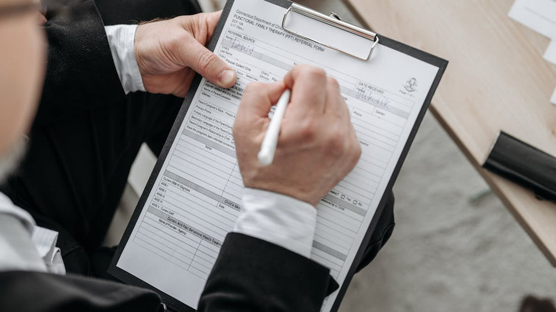 Person signing an insurance document — anti-theft devices and car insurance